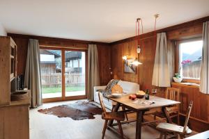een eetkamer met een tafel en stoelen en een raam bij Almrausch Apartments in Sesto