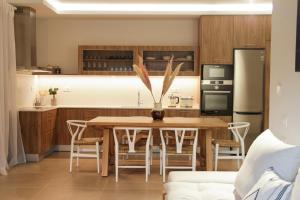 a kitchen with a table and chairs and a refrigerator at Elounda Katikia Luxury Living in Elounda