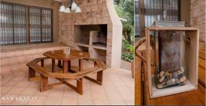 a patio with a table and a stone fireplace at 4 Gazelle Guesthouse in Nelspruit