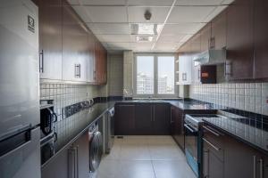 a large kitchen with a washer and dryer at HiGuests - Incredible City Views in Deira 5-min to Airport in Dubai