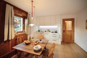 een keuken met een houten tafel en een eetkamer bij Almrausch Apartments in Sesto