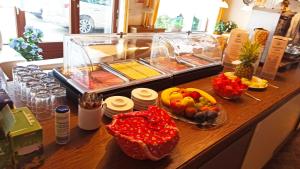 a buffet with fruits and vegetables in bowls on a counter at Appartement - Pension Adlerhorst in Velden am Wörthersee +19 photos