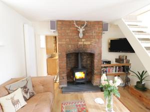 a living room with a brick fireplace and a couch at Prospect Cottage in Malvern Wells