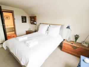 a bedroom with a large bed with white sheets at Prospect Cottage in Malvern Wells