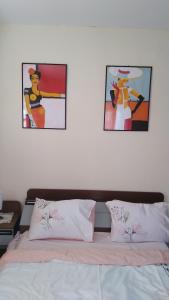 een slaapkamer met 2 foto's aan de muur en een bed bij Apartman Ipak Se Okrece in Trebinje
