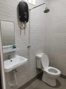a bathroom with a toilet and a sink at Faris's Homestay & Resort in Pasir Puteh