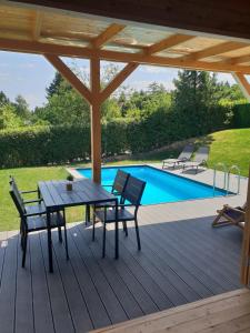 een patio met een tafel en stoelen en een zwembad bij Woody House in Krčedin