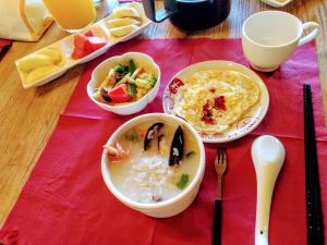 una mesa con tazones de comida sobre un mantel rojo en Matsu Seaside View Homestay en Nangan