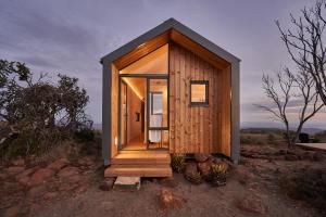 a small wooden tiny house on a hillside at Mount Camdeboo Private Game Reserve by NEWMARK in Graaff-Reinet