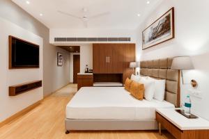 um quarto de hotel com uma cama e uma televisão em Hotel Aketa Rajpur Road Dehradun, Dehradun em Dehradun