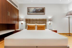 a bedroom with a large white bed and two lamps at Hotel Aketa Rajpur Road Dehradun, Dehradun in Dehradun