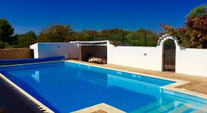 a swimming pool in front of a white building with at Villa Chanteria Carvoeiro fabulous 7 bedroom 7 bathroom villa with AC short walk to the beach in Carvoeiro