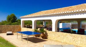 una casa con una mesa azul en un patio en Villa Chanteria Carvoeiro fabulous 7 bedroom 7 bathroom villa with AC short walk to the beach, en Carvoeiro