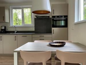 a kitchen with a table with chairs and a bowl on it at Bok's Bungalowpark in Garderen