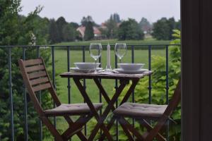 - une table avec 2 chaises et des verres à vin sur le balcon dans l'établissement Studio apartment "Iris", à Ptuj