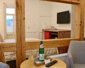 a living room with a bottle on a table at Pension Kurhausblick in Bad Suderode