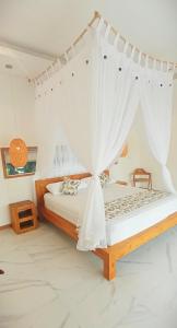 1 dormitorio con 1 cama con mosquitera en Bingin Pura Vida Villas, en Uluwatu