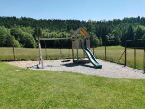 um parque infantil com um escorrega e uma estrutura de jogos em U Waltera em Police nad Metují