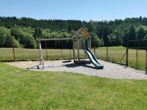 een speeltuin met een glijbaan en een speelstructuur bij U Waltera in Police nad Metují