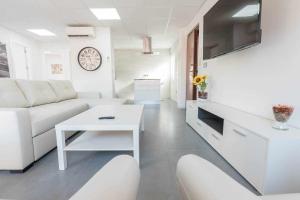 Sala de estar blanca con sofá y mesa en Apartamento Céntrico Salzillo, en Murcia