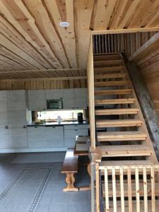 a wooden staircase in a room with a kitchen at Kojamopirtit in Kolari
