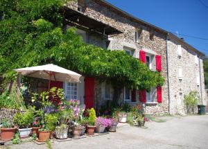 una sombrilla frente a un edificio con macetas en L'aligier - Les gites de Pierregras, en Vals-les-Bains