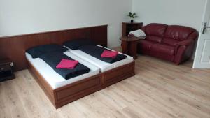1 dormitorio con cama con almohadas rosas y sofá en Laguna ubytovanie 2 A en Trenčín