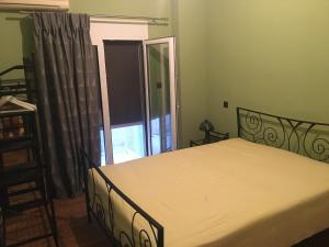 een slaapkamer met een bed en een groot raam bij Cosy and comfort flat, heart of Athens in Athene