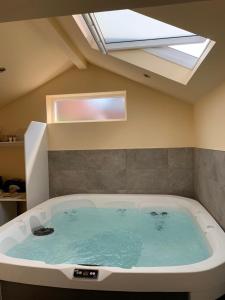 a large bath tub in a room with a skylight at The Forge Guest Rooms in Long Whatton