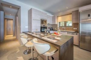 a kitchen with a large island with white bar chairs at Luxury Villa Zante Villa Avril 3 Bedrooms Astounding Sea Views & Private Pool & Jacuzzi Keri in Marathias