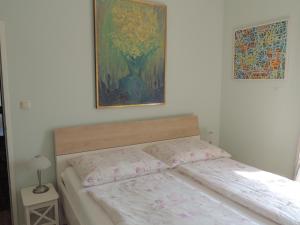łóżko w sypialni z obrazem na ścianie w obiekcie Appartement " Am Fasangarten " w Wiedniu