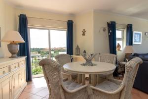 ein Esszimmer mit einem weißen Tisch und Stühlen in der Unterkunft Luxury Townhouse n10 - Front-line Sea views in Ferragudo