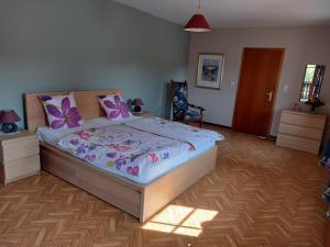 1 dormitorio con 1 cama grande con mariposas moradas. en Ferienwohnung Setzer Mühle, en Saint-Vith