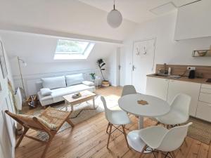 een keuken en een woonkamer met een tafel en stoelen bij Le repaire du Cap-hornier in Rezé
