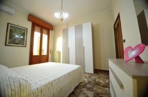 um quarto com uma cama e um coração cor-de-rosa numa cómoda em AL CASTELLO Appartamenti em Torricella