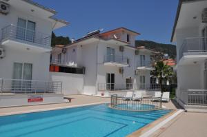 a villa with a swimming pool and two buildings at Sarıgerme Apart in Sarigerme