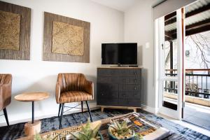 een woonkamer met een televisie en een stoel bij Avemore Jan Cats No 3 with backup power for loadshedding in Stellenbosch