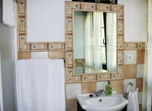 a white sink sitting under a mirror in a bathroom at Hospedaje Angelica in Santillana del Mar