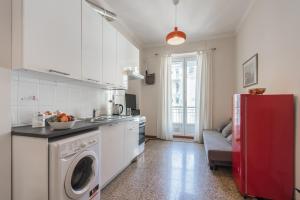 kuchnia z pralką i czerwoną lodówką w obiekcie Appartamento Agnelli vicino al Pala Alpitour by Wonderful Italy w Turynie