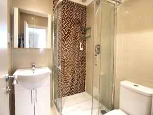 ein Badezimmer mit Dusche, Toilette und Waschbecken in der Unterkunft Queen Victoria Apartments in London