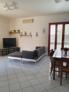 Appartamento Ionios في نوتو مارينا: غرفة معيشة مع أريكة وتلفزيون بشاشة مسطحة