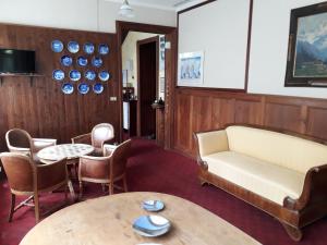 a living room with a couch and a table and chairs at Hotel Villa Tedaldi in Gressoney-Saint-Jean