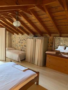 una camera con 2 letti e un soffitto in legno di Guesthouse Kamara II a Monemvasía