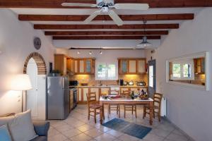 kuchnia ze stołem, krzesłami i lodówką w obiekcie Panorama Villas Corfu 3 Bedroom Villa Sea View With Private Pool w mieście Arillas