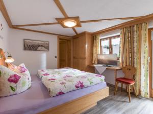 Schlafzimmer mit einem Bett und einem Schreibtisch mit einem TV in der Unterkunft Haus Tiefenbacher in Brixen im Thale