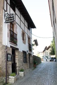 a building with a sign on the side of a street at Hospedaje Angelica in Santillana del Mar