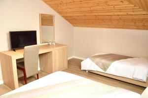 Dormitorio con escritorio, cama y TV en Alis Hotel en Shkodër