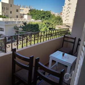 a balcony with two chairs and a table on a balcony at Sweet Home Hostel- No Egyptian in Hurghada