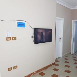 a room with a tv on a wall at Sweet Home Hostel- No Egyptian in Hurghada