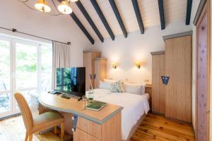 a bedroom with a bed and a desk with a computer at Landhotel Am Rothenberg in Uslar